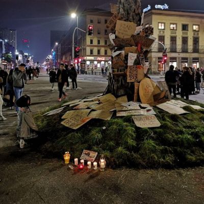 Een demonstrant knielt bij de Palmboom van Warschau