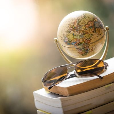Planning the next journey: Miniature globe and sunglasses on a s