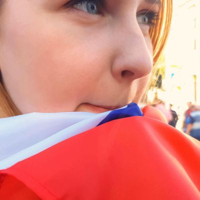 Girl wrapped in national flag standing among crowd, election campaign, politics